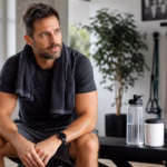 Hombre después de un entrenamiento con agua, bandas de resistencia y un envase de suplemento neutro para el soporte del flujo sanguíneo